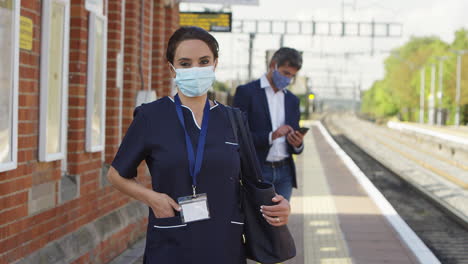 Porträt-Einer-Krankenschwester-Auf-Dem-Bahnsteig-Mit-PSA-Gesichtsmaske,-Die-Während-Einer-Pandemie-Zur-Arbeit-Pendelt