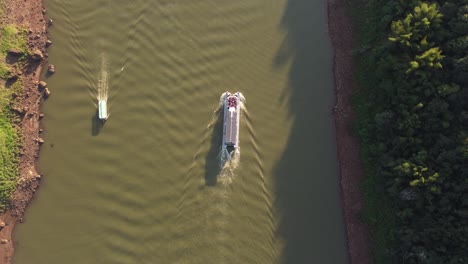dos barcos turísticos navegando en el río iguazú al atardecer, frontera entre argentina y brasil