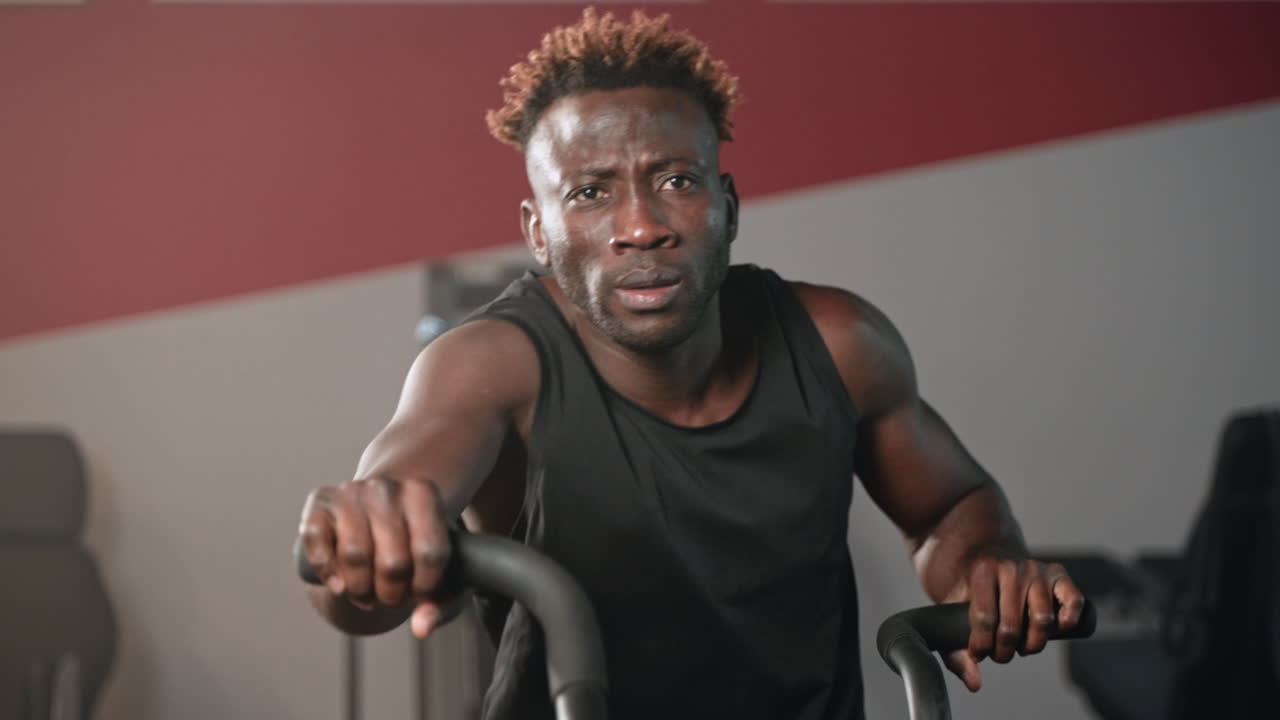 Man Working Out on a Stationary Bike in a Gym