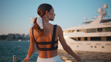 woman by a luxury yacht at sunset