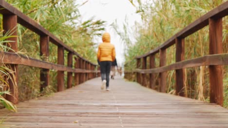 Couple-followed-by-a-child-on-a-wooden-walkway