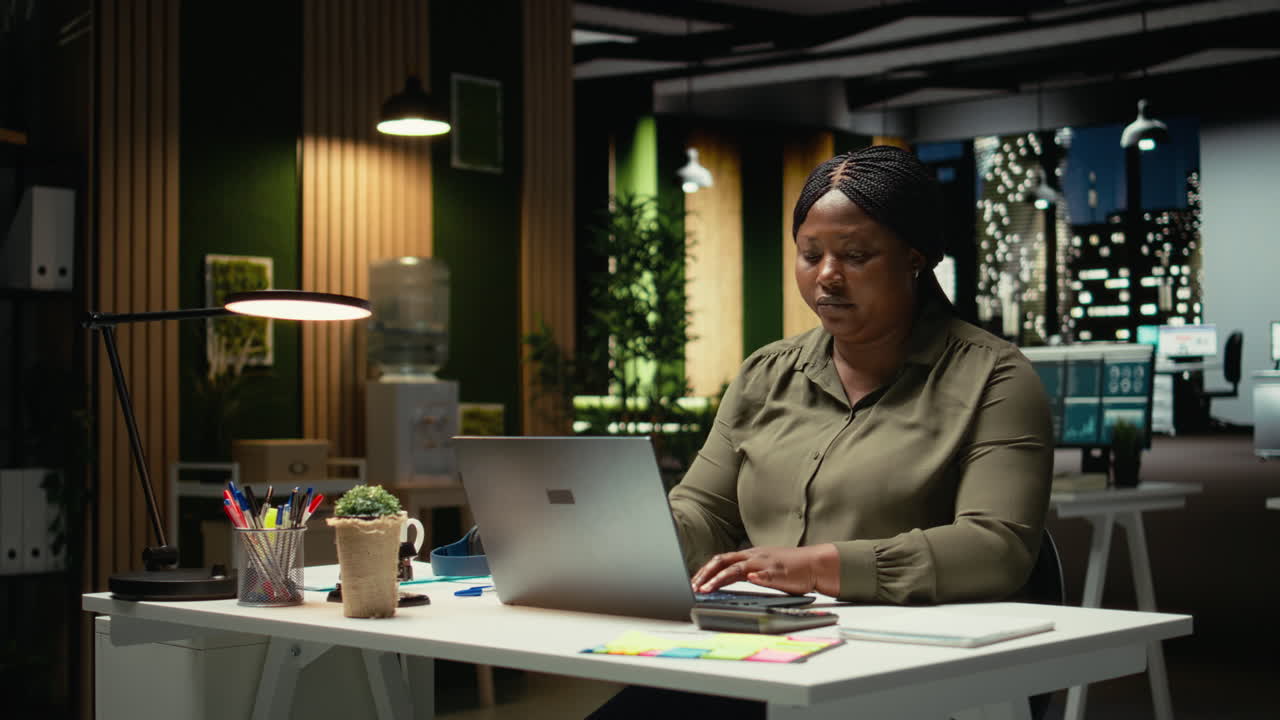 African american woman closing her laptop and office lamp