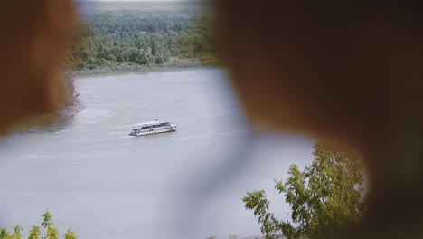 ship sails on river with forest on bank and blurred couple