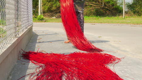 laying red colored straws in the sun before weaving them in the carpet or mattress