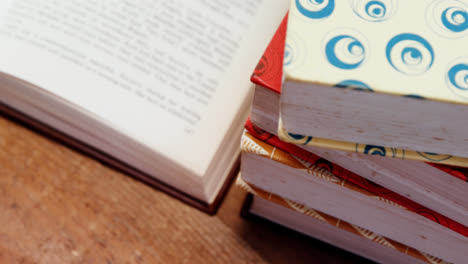 Animation-of-paint-brush-and-palette-with-geometry-set,-over-books-piled-on-desk