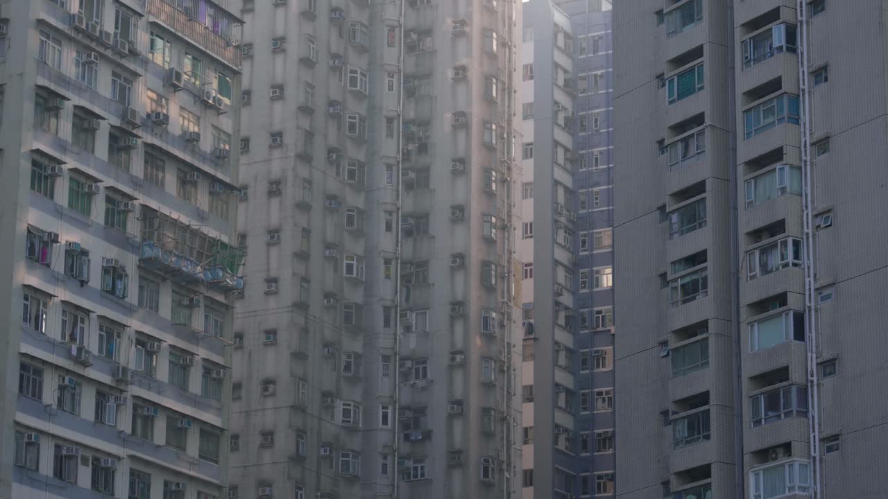 Vista panorámica de edificios de apartamentos y rascacielos en el centro de Hong Kong, China, en un día soleado, mostrando la densa vida urbana y la arquitectura moderna.