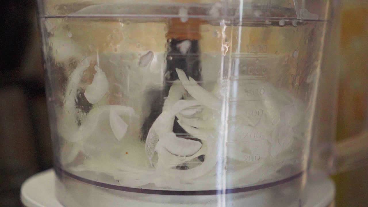 식품 가공기 가 양파 를 잘라내는 느린 움직임 의 클로즈업