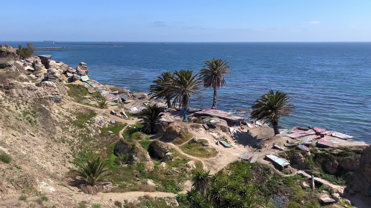 panorámica a través del desmoronamiento de la ciudad hundida ruinas rocosas cubiertas de graffiti en la costa de san pedro