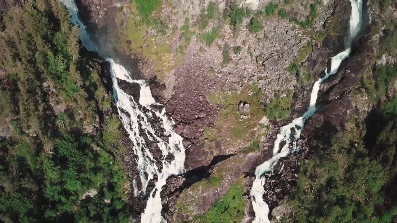 vista aérea de un avión teledirigido de una gran cascada en noruega y un bosque verde en el fondo