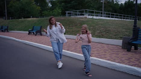 mother and daughter dancing in the park