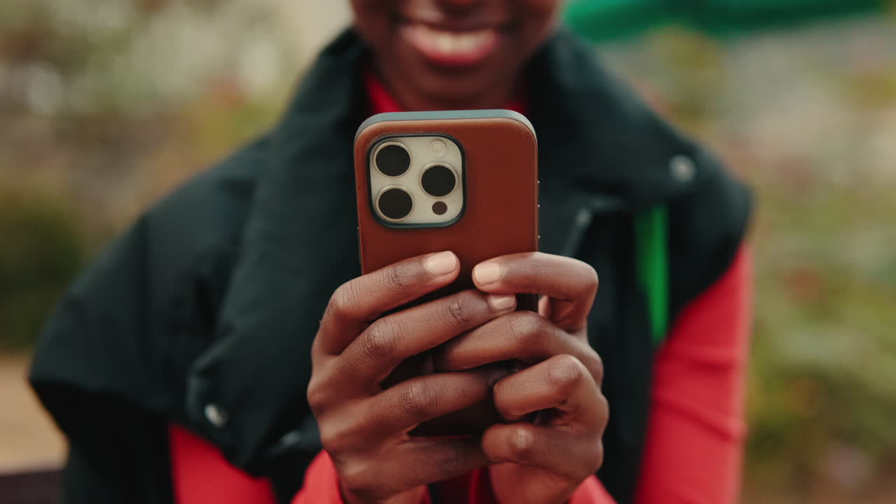 Close-up of Woman's Hands Holding and Using a Smartphone Outdoors