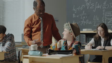 teacher assisting students in a classroom setting