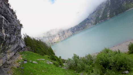 Vuelo-Aéreo-Junto-A-Una-Cascada-En-Un-Paisaje-Montañoso,-Drone-Volando-Hacia-Adelante-Sobre-El-Lago-Azul---Lago-Oeschinen,-Suiza