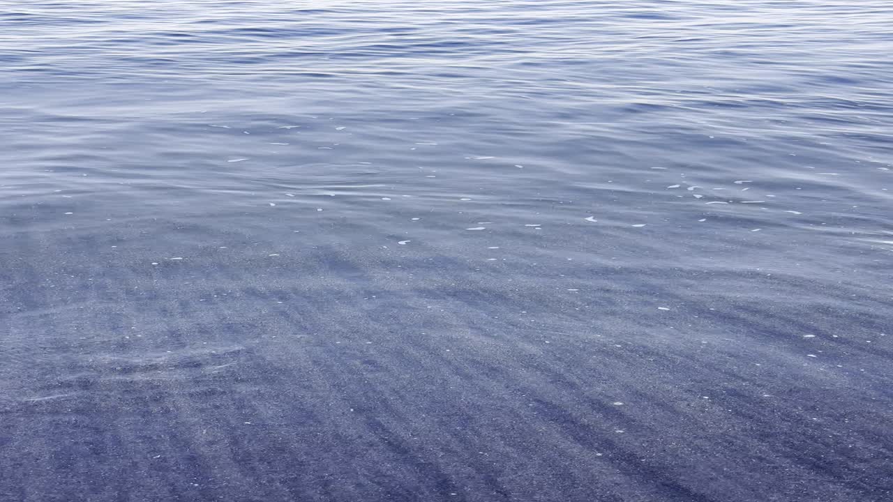 Gentle Ocean Waves Washing onto Dark Sandy Beach