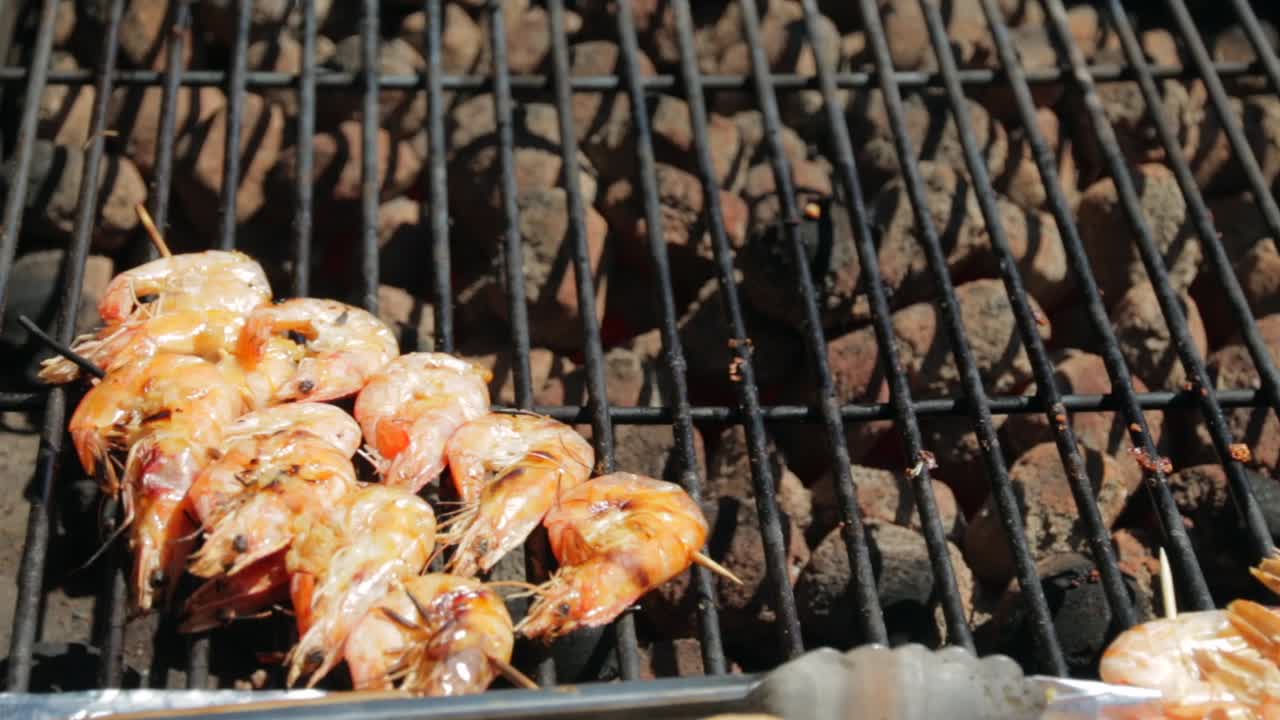 Shrimp cooking on a barbecue with hot coals.