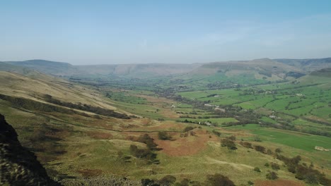 toma aérea del pueblo de edale en el fondo del valle desde la cima de los picos de las colinas, distrito de los picos, reino unido