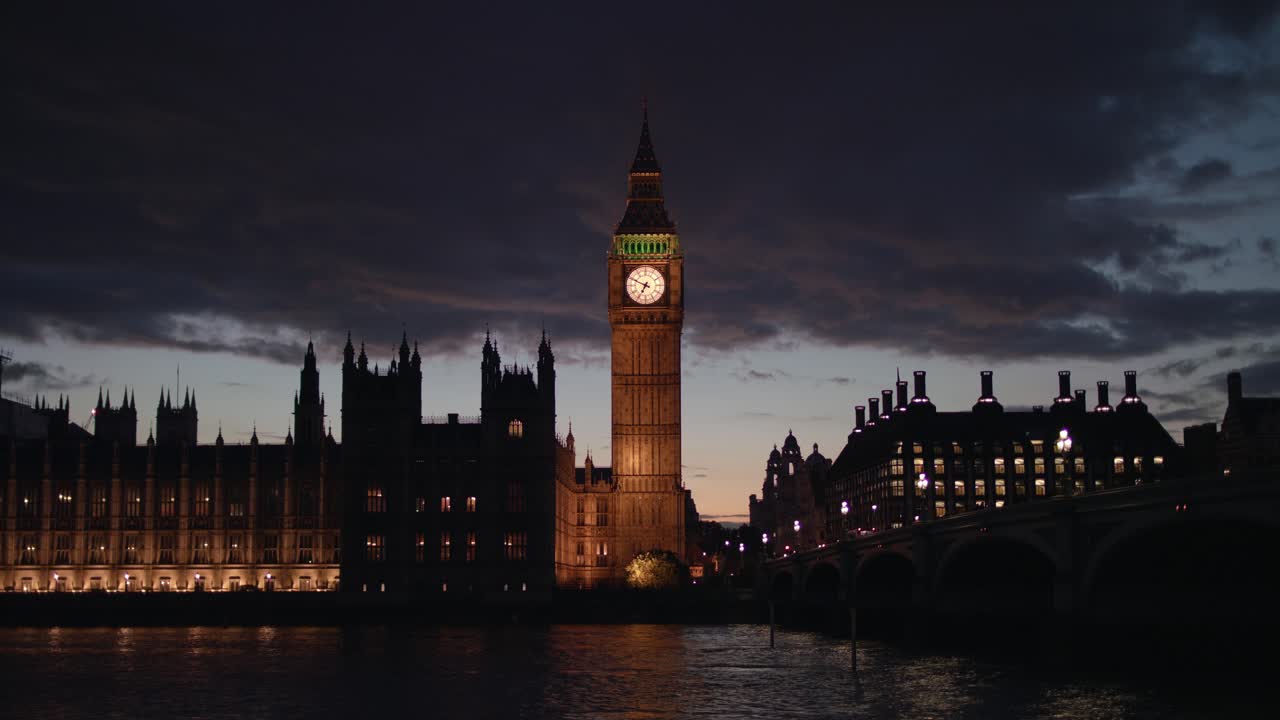 L'iconica torre del Big Ben di Westminster brilla di luci dorate accanto al Parlamento e al ponte illuminati, i cui riflessi scintillano sul Tamigi dopo il tramonto