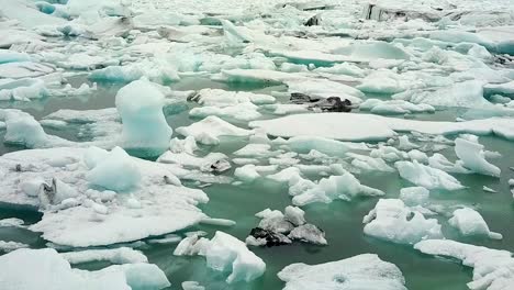 melting icebergs floating in sea while snowing