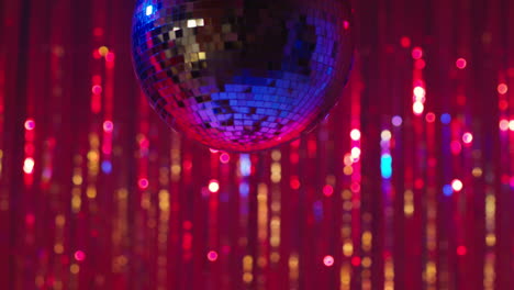 close up of revolving mirrorball in night club or disco with flashing strobe lighting and sparkling lights in background 2