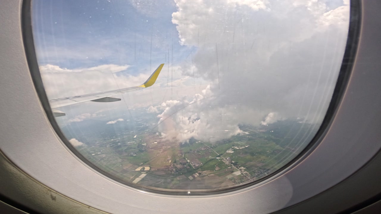 View from airplane window, wing above clouds flying Clark to Malay Philippines