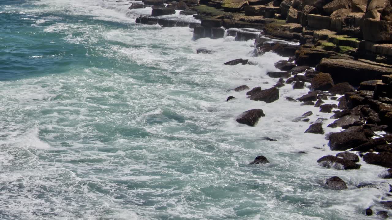Waves crash on rocky shore in southern Portugal during the daytime
