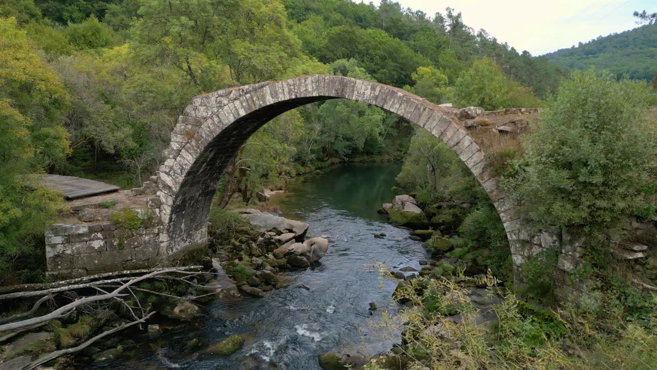 Isolated Stone Arch Bridge Over Flowing River Of Avia Near Cenlle, Ourense Province, Spain. Aerial Shot