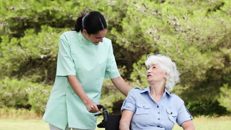 nurse talking to an old woman in a wheelchair