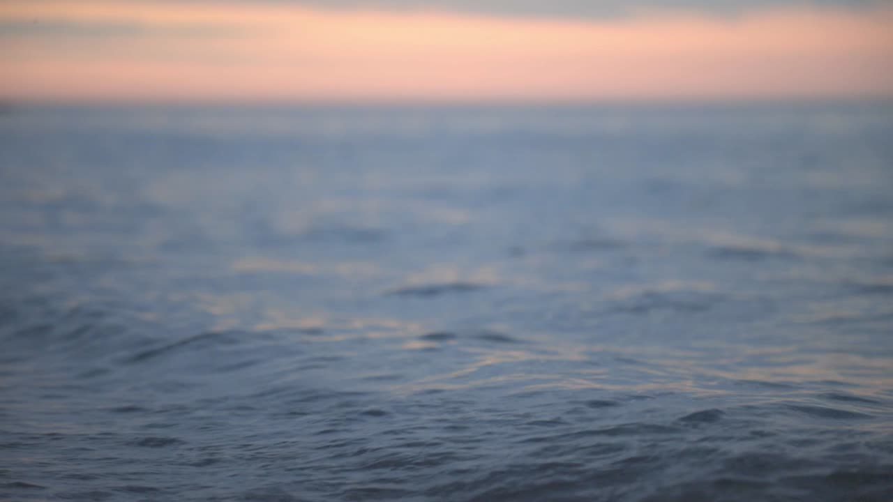 Small Waves Rolling By The Sea At Sunset - Low-Level Shot
