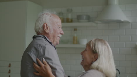 happy senior couple dancing in the kitchen