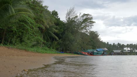 una toma en cámara lenta de la playa en un día lluvioso con un barco hundido en el fondo