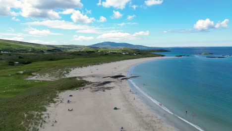 glassilaun beach located in the connemara region of county galway,is a long stretch of white sand, with a backdrop of rugged mountains and the bright blue waters of the atlantic ocean