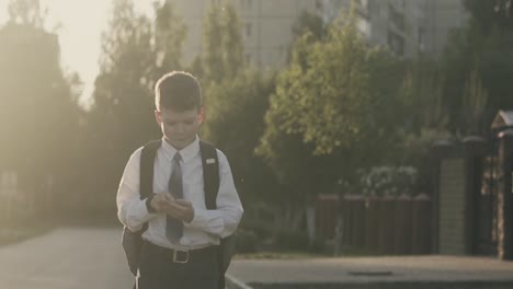 cu tracking slow motion schoolboy walks down the street and thinks counts on his fingers