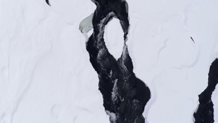 Torrente che scorre su un'area innevata durante l'inverno 4k