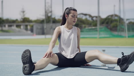 woman stretching on a running track