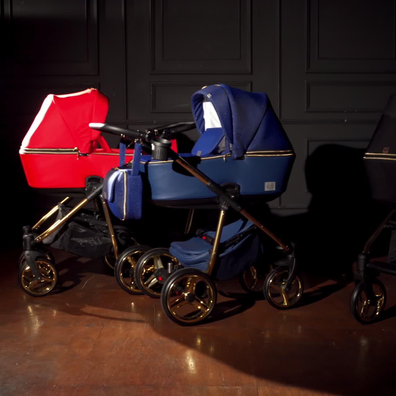 Modern new prams with shining wheels are pushed to the centre of dark room. Beautiful strollers presentation