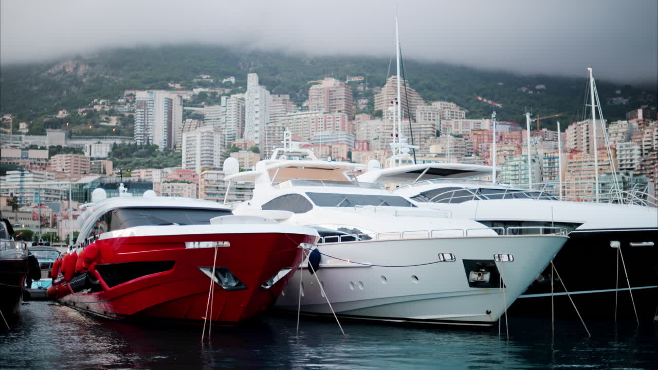 Vista delle barche ormeggiate nel porto turistico di Monaco con lo skyline della città sullo sfondo