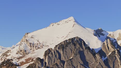 Drone-footage-revealing-the-silhouette-of-snow-capped-peaks-at-sunrise