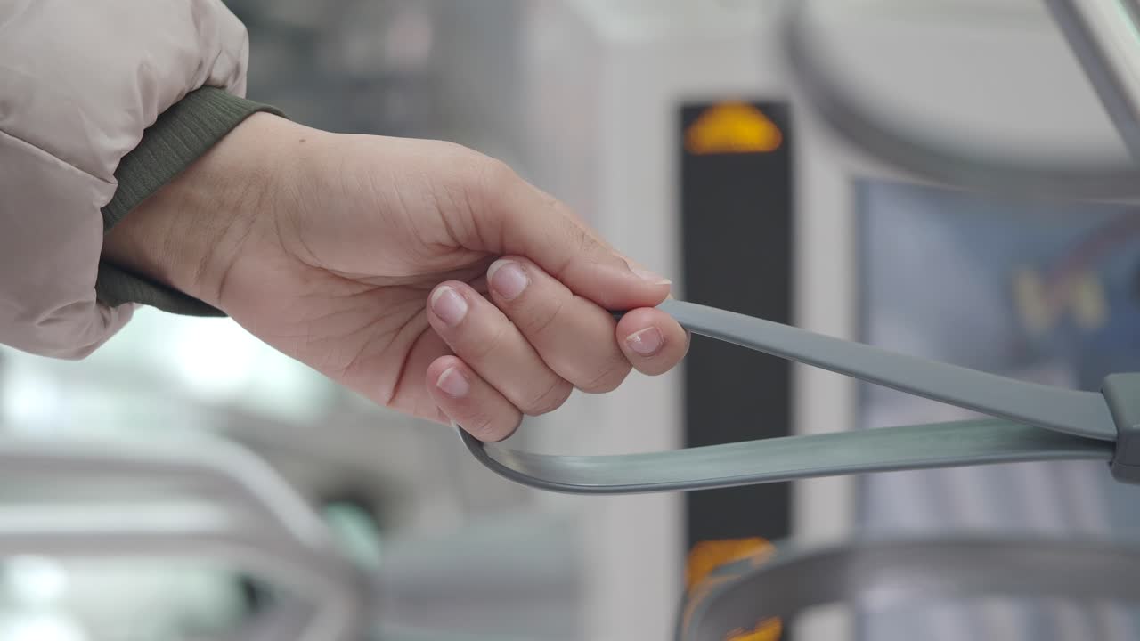 A person holding a hand strap on public transport