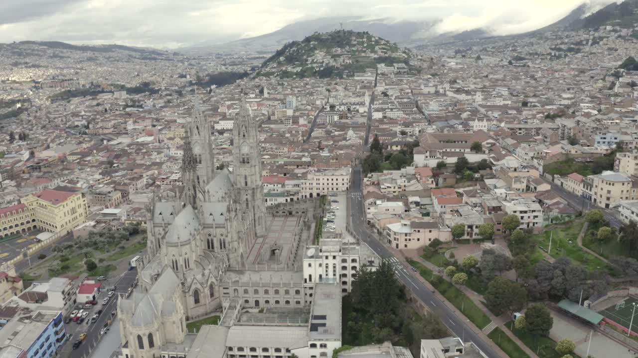 Drone shot of La Basilica del Voto Nacional located in the historic center of Quito, Ecuador. Virgin of Legarda over the Panecillo during quarantine. Houses and empty streets.