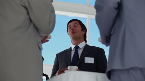 Low-angle-view-of-a-businessman-holding-coffee-cup