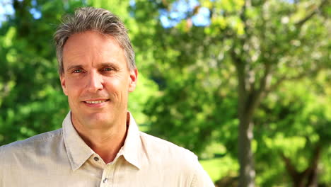 Happy-man-smiling-at-camera-in-the-park