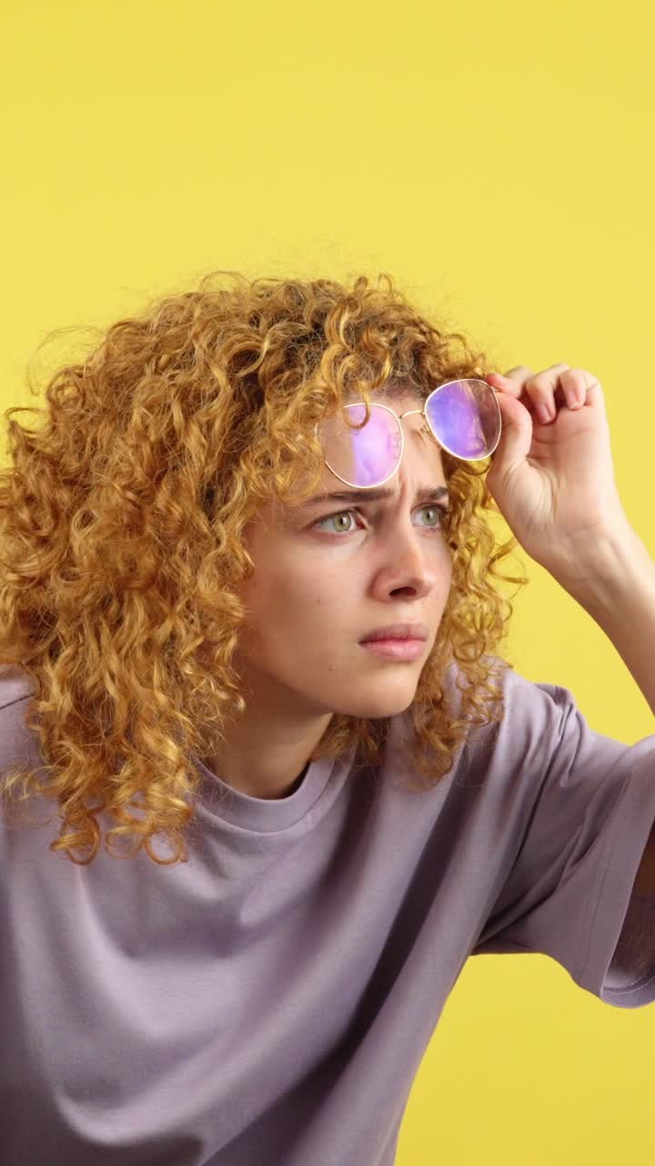 Young Woman Adjusting Glasses with a Confused Expression