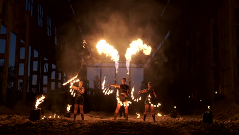 cámara lenta: espectáculo de fuego en el hangar muestra a tres mujeres artistas y un hombre con lanzallamas