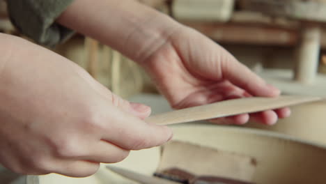 hands of potter choosing wooden rib