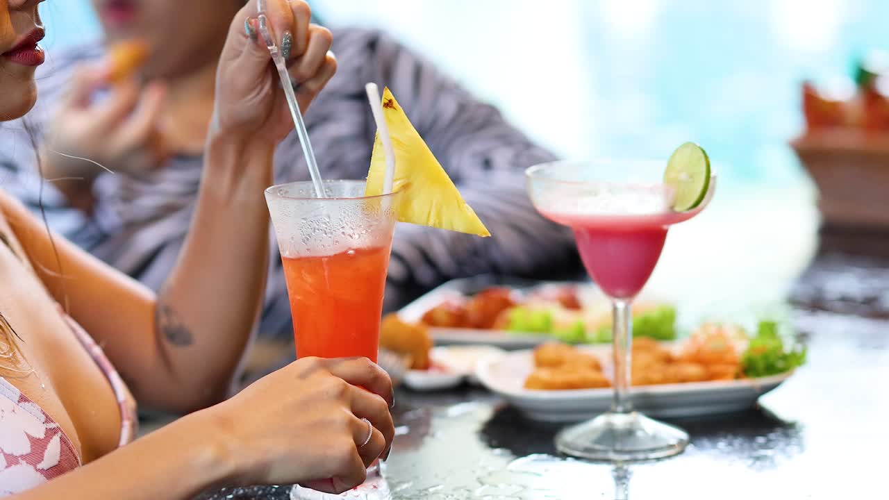 disfrutando de bebidas y bocadillos junto a la piscina