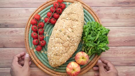 pan de comida entera, manzana y tomate cereza en la mesa