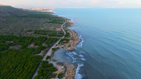 ocean coast waves crashing on countryside shore near road in santa pola, spain