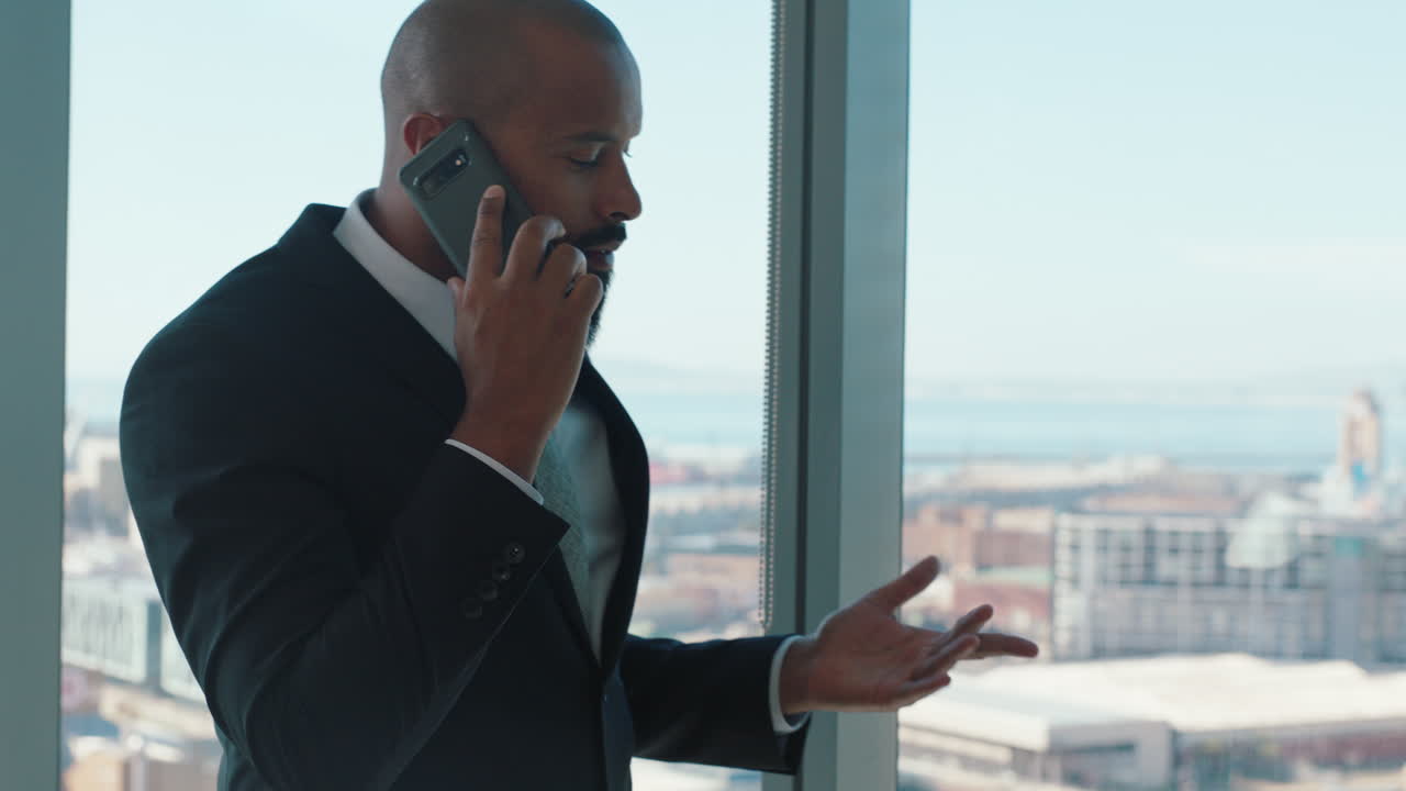 uomo d'affari fiducioso che usa lo smartphone che parla con un cliente dirigente aziendale che negozia un affare aziendale amministratore delegato dell'azienda che fa una telefonata in ufficio guardando fuori dalla finestra