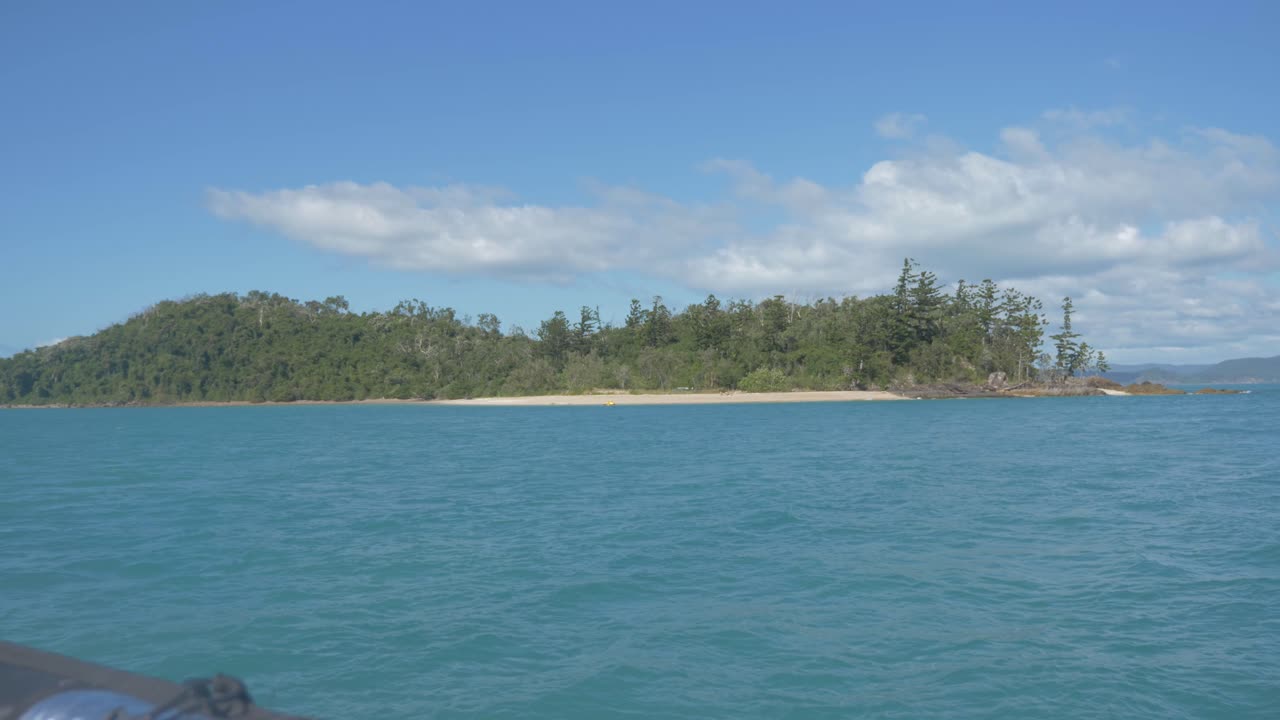 울창한 녹색 해밀턴 섬의 항해 보트에서 볼 수 있는 부시랜드로 덮여 있고 호주 퀸즐랜드 주 휘트선데이즈에 있는 잔잔한 푸른 바다로 둘러싸여 있습니다.