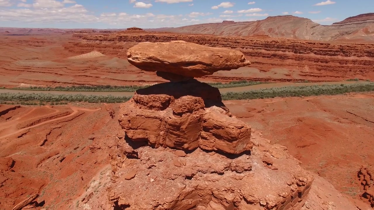 Ripresa aerea ravvicinata con drone in circolo di Mexican Hat Rock in una giornata limpida nello Utah sud-orientale.